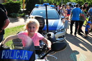 Dziewczynka siedząca na policyjnym motocyklu
