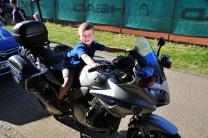 Chłopiec siedzący na policyjnym motocyklu