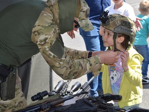 policjant kontrterrorysta zakłada dziewczynce na głowę kask