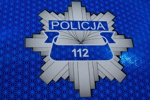 Odznaka policyjna na której napisany jest nr 112