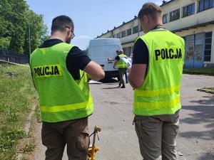 zdjęcie dwóch policjantów w żółtych kamizelkach z napisem policja