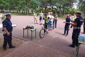 Uczestnicy Finału podczas poszczególnych etapów konkursu - testu wiedzy i prób sprawnościowej jazdy na rowerze - pod okiem policjantów