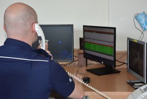 Policjant - oficer dyżurny odbiera telefon w czasie pełnienia służby.