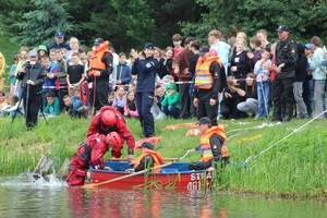 Na zdjęciu uczestnicy spotkania profilaktycznego "Kręci mnie bezpieczeństwo nad wodą". Na pierwszym planie strażacy w łódce.