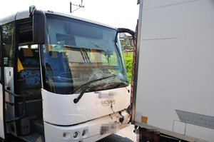 Tył dostawczego iveco oraz przód autobusu z rozbitą szybą czołową i otworzonymi drzwiami przednimi