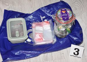 Pudełko plastikowe, woreczki oraz słoik w których znajdują się substancje