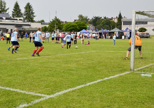 Zawodnicy PSP oraz SW w takcie akcji pod bramką SW. W tle widzowie oraz stoiska służb