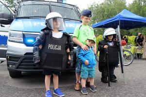 Czwórka dzieci stojąca przed radiowozem