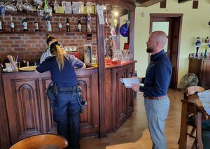 Plakat kampanii „Alkohol- ograniczona dostępność”, oraz funkcjonariusze kontrolujący placówki handlowe