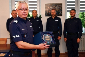 Komendant Wojewódzki Policji w Rzeszowie wręcza policjantom pamiątkowe grawertony i składa gratulacje.