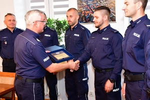 Komendant Wojewódzki Policji w Rzeszowie wręcza policjantom pamiątkowe grawertony i składa gratulacje.