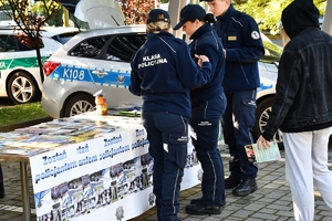 Policjanci i uczestnicy święta bezpieczeństwa podczas prezentacji stoisk na parkingu przed WSPiA.