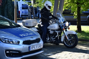 Policjanci i uczestnicy święta bezpieczeństwa podczas prezentacji stoisk na parkingu przed WSPiA.