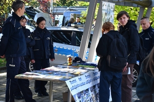 Policjanci i uczestnicy święta bezpieczeństwa podczas prezentacji stoisk na parkingu przed WSPiA.