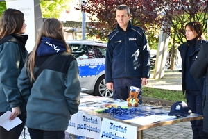 Policjanci i uczestnicy święta bezpieczeństwa podczas prezentacji stoisk na parkingu przed WSPiA.