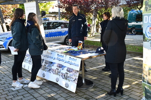 Policjanci i uczestnicy święta bezpieczeństwa podczas prezentacji stoisk na parkingu przed WSPiA.