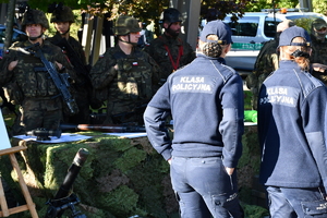 Policjanci i uczestnicy święta bezpieczeństwa podczas prezentacji stoisk na parkingu przed WSPiA.