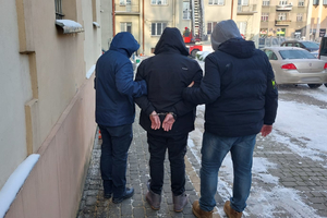 Policjanci prowadzą zatrzymanego