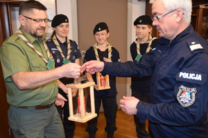 Harcerze przekazują Komendantowi Wojewódzkiemu Policji w Rzeszowie świecę ze Światełkiem Betlejemskim