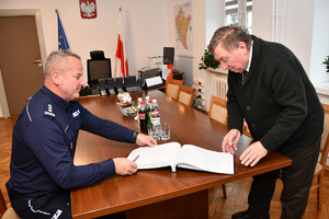 Komendant wpisuje się do księgi pamiątkowej Stowarzyszenia.