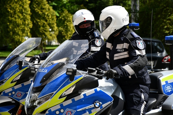 Policjanci na motocyklach przygotowują się do jazdy.