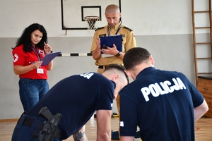 Policjanci podczas rozpoczęcia konkursu ratowników medycznych w auli OPP w Rzeszowie, a także podczas pisania testu wiedzy.