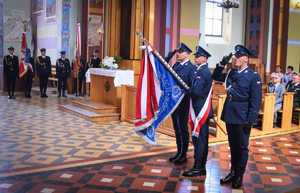 poczet sztandarowy, trzej policjanci oddają honor sztandarem