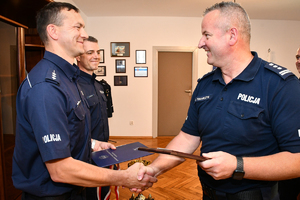 Komendant Wojewódzki Policji w Rzeszowie insp. Jarosław Tokarczyk składa gratulacje najlepszym policyjnym wodniakom w kraju. Komendant po prawej, dwaj reprezentanci garnizonu podkarpackiego po lewej.