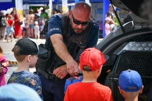 Policjanci przy stoisku policyjny wśród uczestników pikniku z okazji Dnia Dziecka na placu przed TVP w Rzeszowie