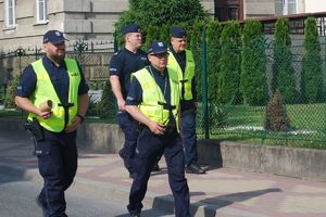 Ćwiczenia sztabowe. Policjanci idą ulicą obok budynku