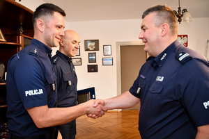 Komendant Wojewódzki Policji w Rzeszowie insp. Jarosław Tokarczyk gratuluje najlepszym ratownikom policyjnym. Po prawej komendant, po lewej dwaj nagrodzeni policjanci.