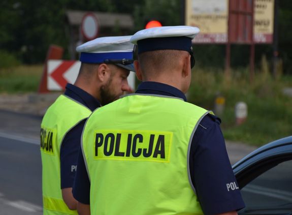 Dwaj funkcjonariusze stojący przy samochodzie, w tle ulica. Zdjęcie KPP Jarosław