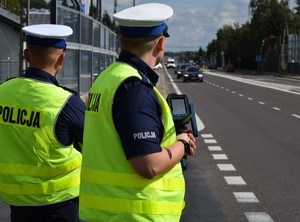 umundurowani policjanci ruchu drogowego na drodze z ręcznym miernikiem prędkości