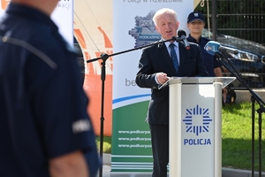 Policjanci i zaproszeni goście podczas uroczystości otwarcia komisariatu. Policjanci stoją na parkingu przed budynkiem.