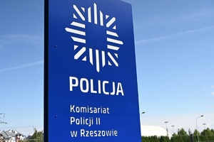 Policjanci i zaproszeni goście podczas uroczystości otwarcia komisariatu. Policjanci stoją na parkingu przed budynkiem.