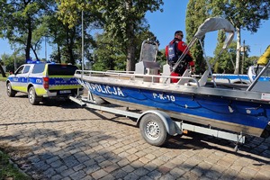 Policjanci podczas działań na terenach popowodziowych. Funkcjonariusze w specjalnych strojach patrolują tereny zalane przez wodę