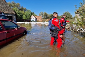 Policjanci podczas działań na terenach popowodziowych. Funkcjonariusze w specjalnych strojach patrolują tereny zalane przez wodę