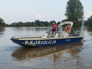 policjanci stermotorzyści w specjalistycznych skafandrach na łodzi