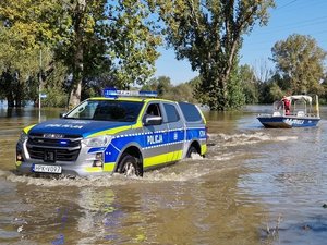 policjanci stermotorzyści w specjalistycznych skafandrach na łodzi