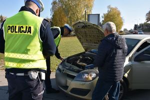 umundurowani policjanci ruchu drogowego kontrolują stan świateł w samochodzie