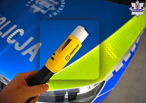 Zdjęcie oznakowanego radiowozu i urządzenia do badania stanu trzeźwości