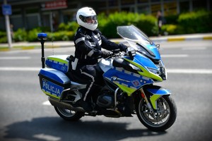 Policjant na oznakowanym policyjnym motocyklu.