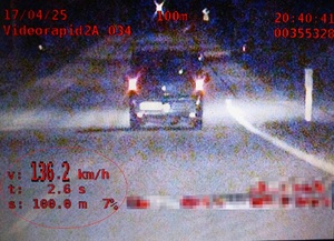 Zrzut ekranowy nagrania z wideorejestratora przedstawiający pojazd, którego kierujący przekroczył dopuszczalną prędkość.