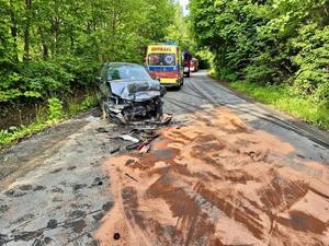 Zdjęcie z miejsca wypadku, na którym widoczny jest uszkodzony pojazd biorący udział w zdarzeniu oraz ambulans.