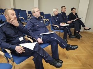 Członkowie komisji siedzący na krzesłach wybierający laureatów na mem  -