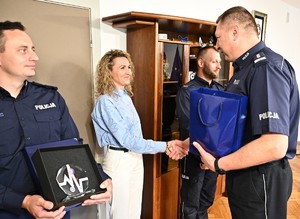 komendant wojewódzki policji w swoim gabinecie wręcza policjantom pamiątkowe grawertony