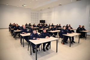 umundurowani policjanci zgromadzeni na auli podczas zakończenia kursu podoficerskiego