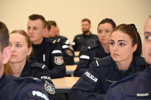 umundurowani policjanci zgromadzeni na auli podczas zakończenia kursu podoficerskiego