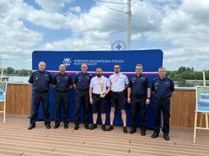 policjanci odbierający puchar z rąk Komendanta