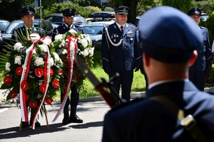 Policjanci podczas uroczystości złożenia kwiatów i zapalenia zniczy przed tablicami pamiątkowymi na frontonie Komendy Wojewódzkiej Policji w Rzeszowie